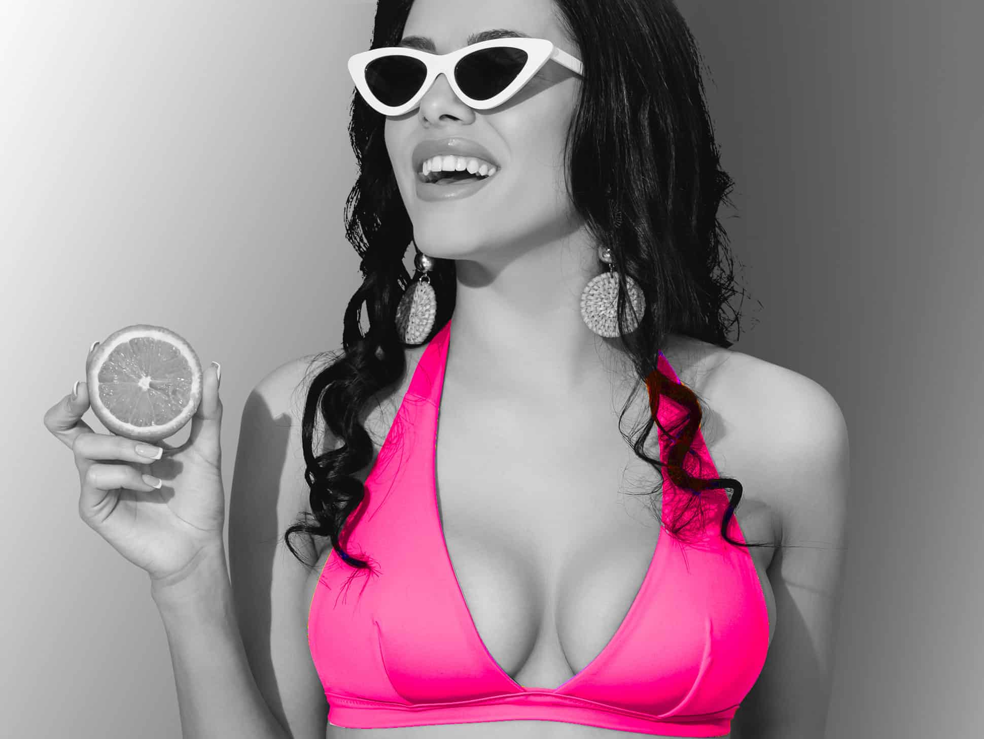 Woman wearing pink bikini poses and smiles
